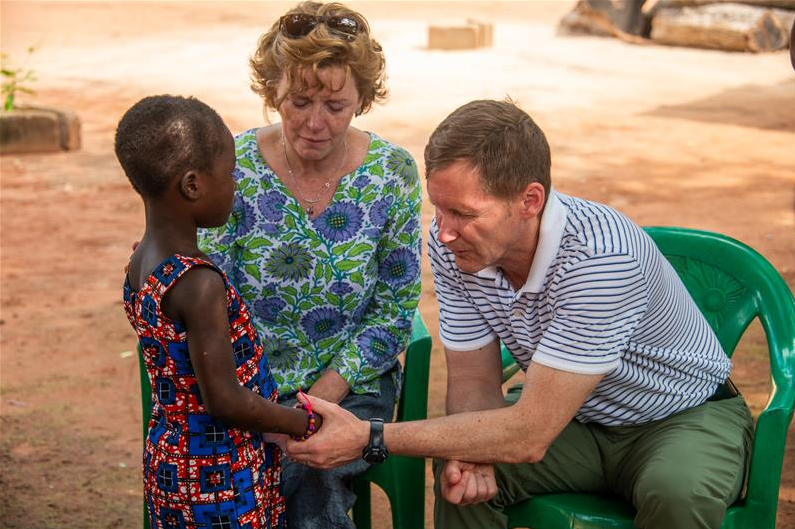 Kristen Colber-Baker praying over child in Togo