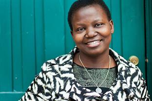 Olive stands in front of a green wall