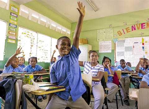 a boy is raising his hand in class