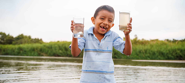 A boy shows clean water in Peru