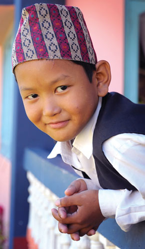 A boy wearing a colorful hat - Worship in Adversity