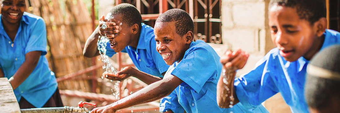 Boys smiling while they have water