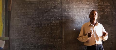 A teacher standing in front of a chalkboard