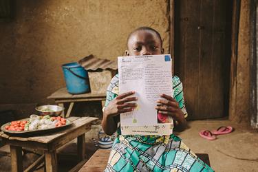 A child holds up sponsor letters