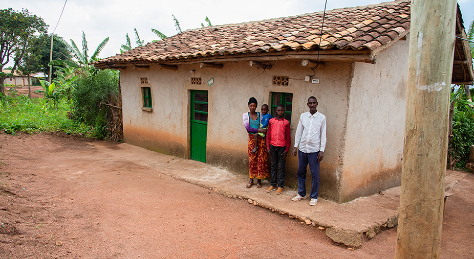 Claude and his family stand in front of their home.
