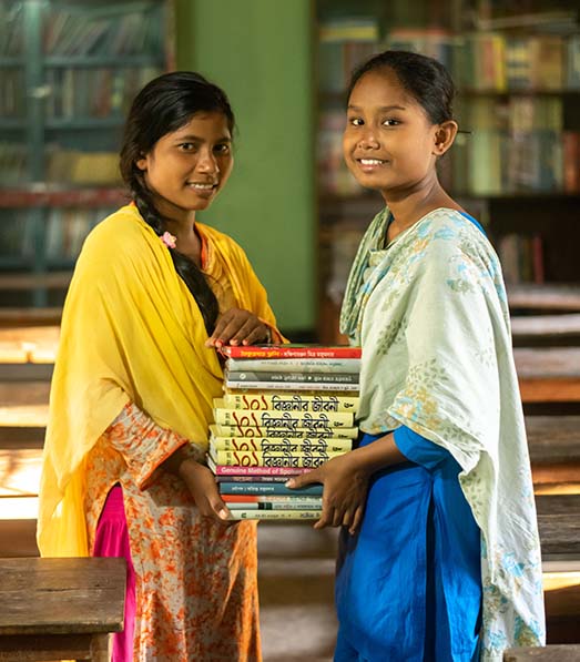 Ripa and Eti hold a stack of books