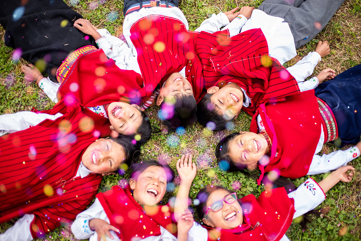 children lay on the ground and laugh