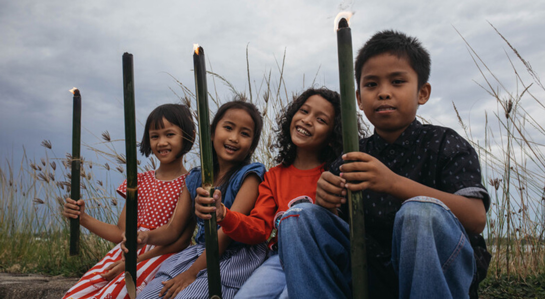 Raya and her friends are holding burning bamboo torches