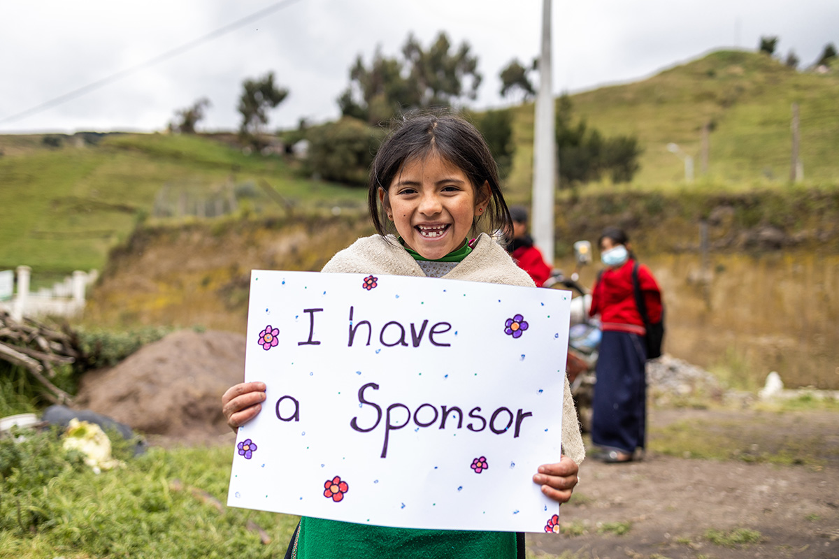 Lizeth holds a sign that reads "I have a sponsor"
