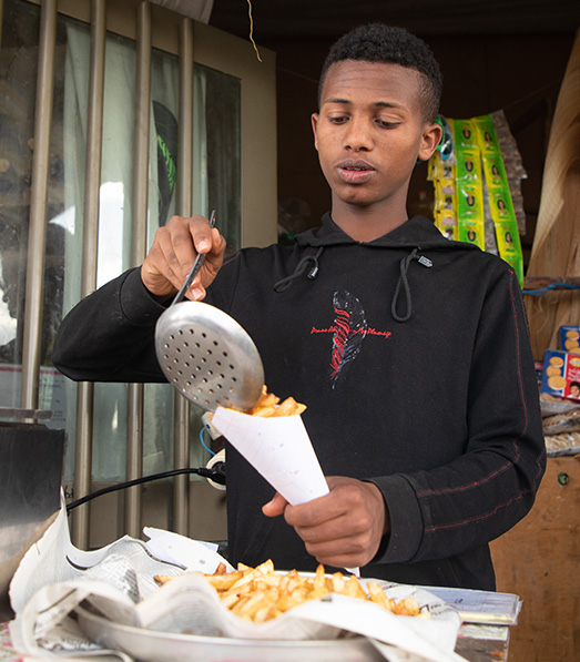Mikiyas serves french fries at his shop