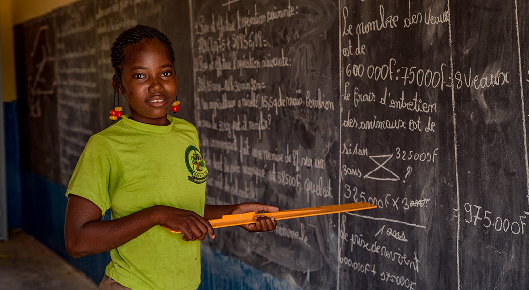 a girl stands at the blackboard