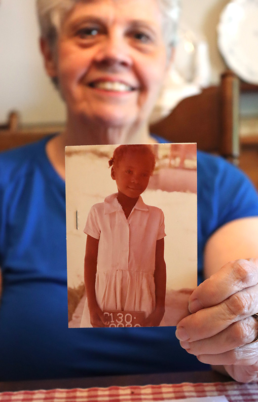Lois holds a picture of a sponsored child
