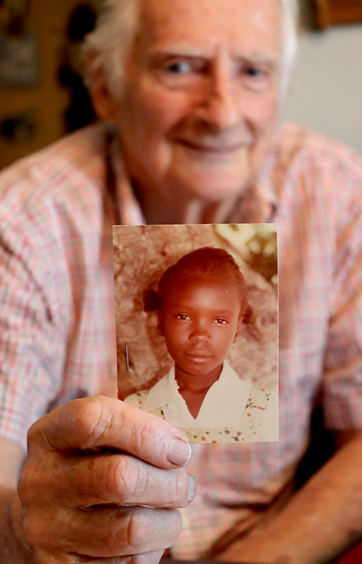 Richard holds a picture of a sponsored child