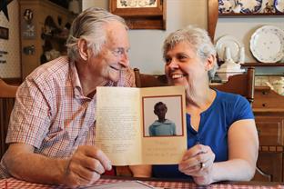 Richard and Lois hold a picture of one of their sponsored children