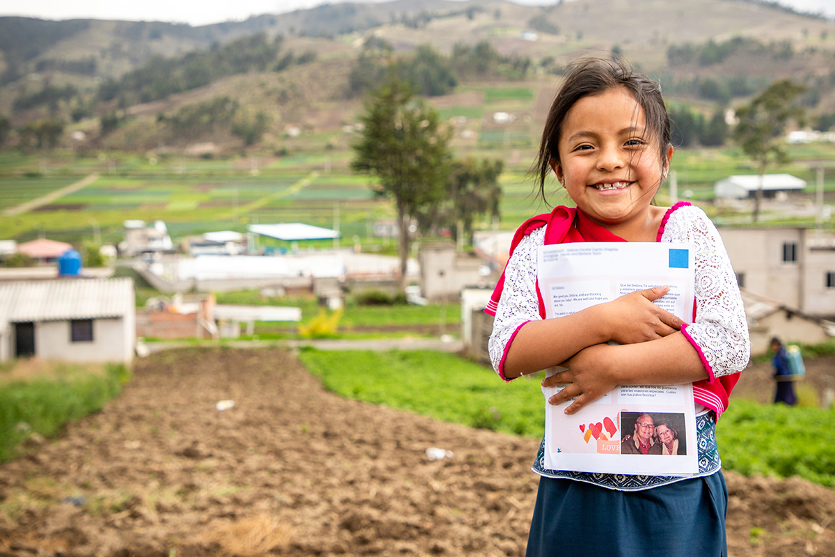 a girl holds a letter from her sponsor