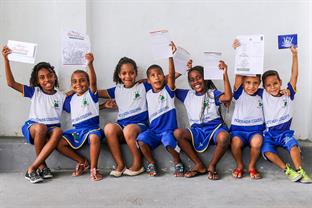 children hold up their letters