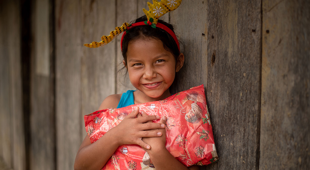 a girl holds a Christmas gift