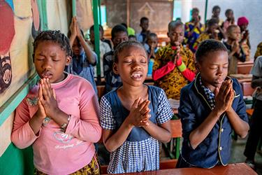 students pray in their classroom