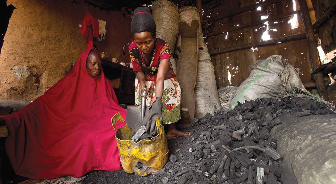 Goretti fills a bucket with charcoal for a customer
