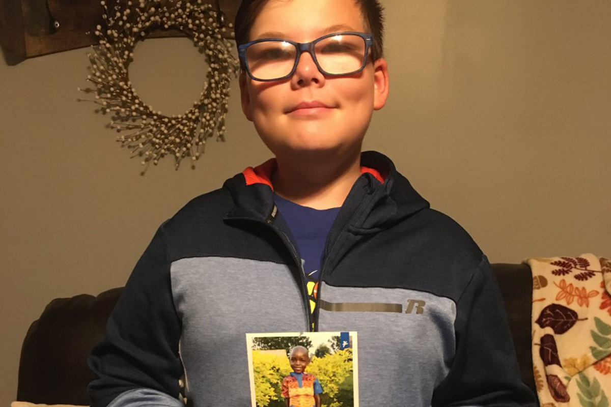 Samuel holds a photo of his sponsored child