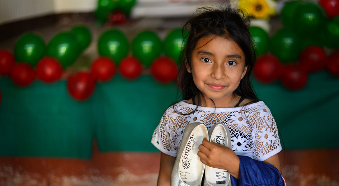 a girl holds a pair of shoes