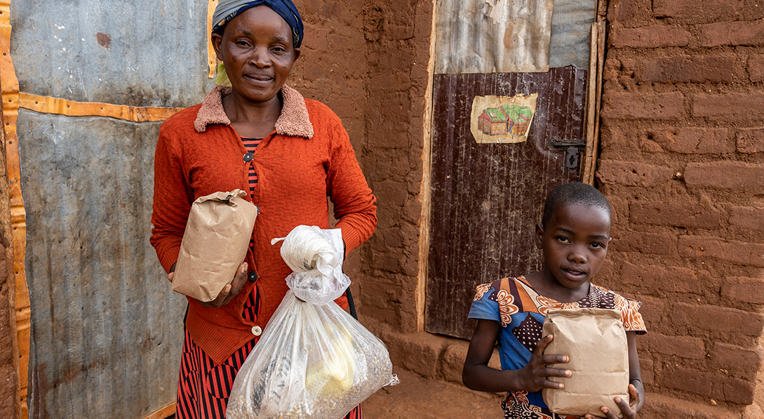 Catherine and her daughter, Stella, hold food packages