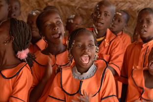 school children sing and clap