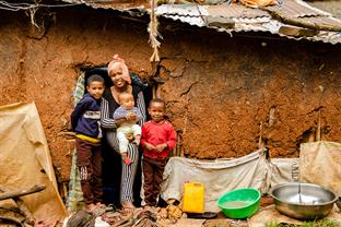 Hanna and her sons stand outside of their home