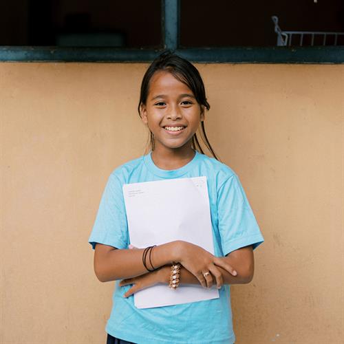 a girl holds a letter from her sponsor