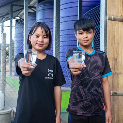 2 children hold glasses of water