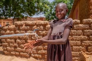 a girl washes her hands