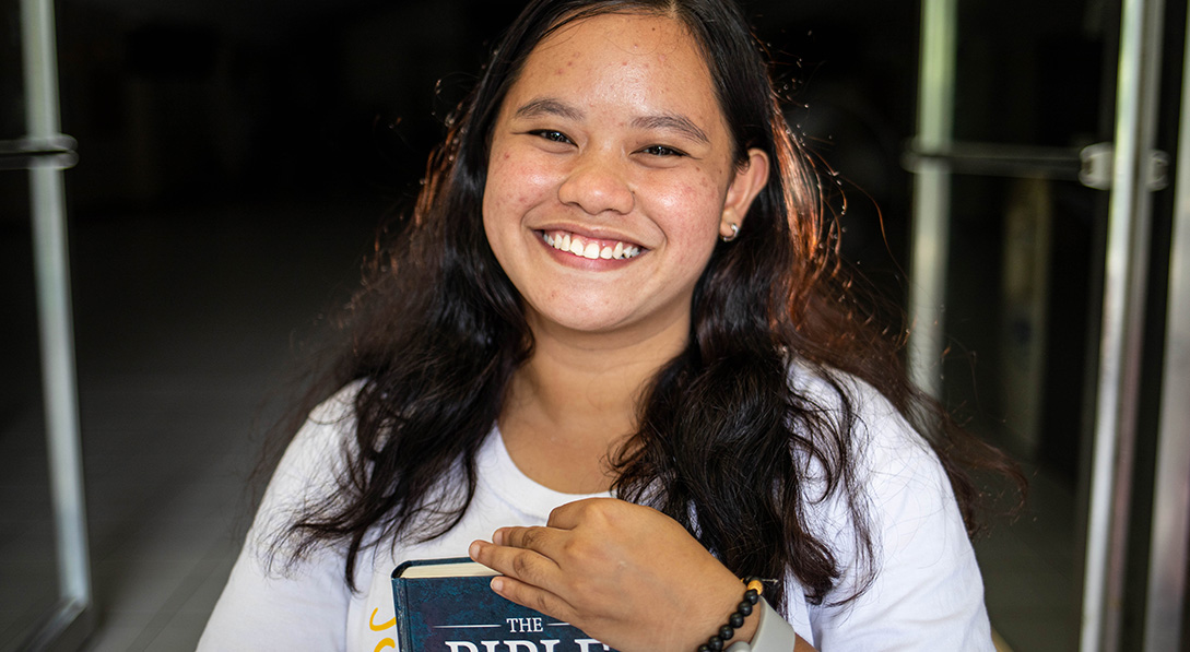 a teen girl holds a Bible