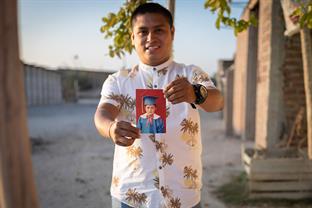 Jhoel holds a picture of himself when he was younger