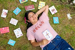 a girl shows off letters from her sponsor