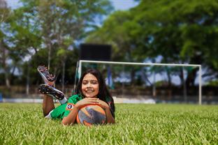 Karla lays on the field with a ball