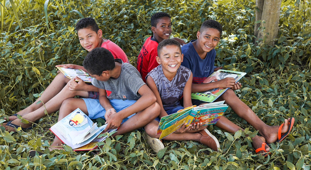 Group of children sitting on grass reading books