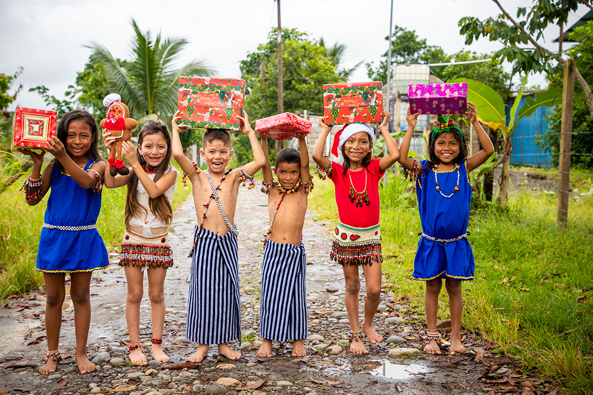 Children holding presents over their heads smiling