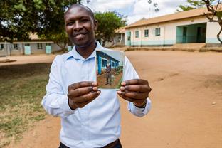 Michael holds a photo of his younger self.