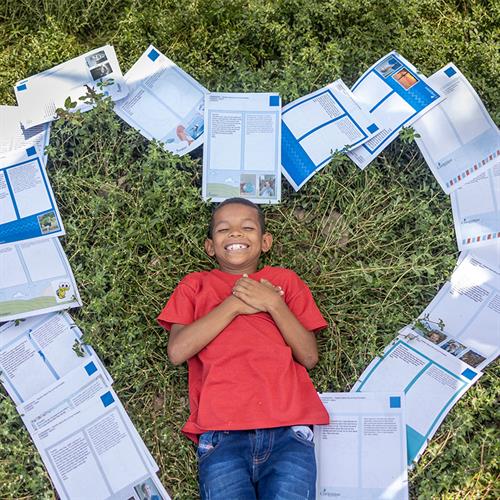 child lays in a heart shape of letters 