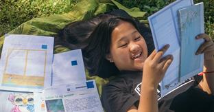 girl smiles while reading letter