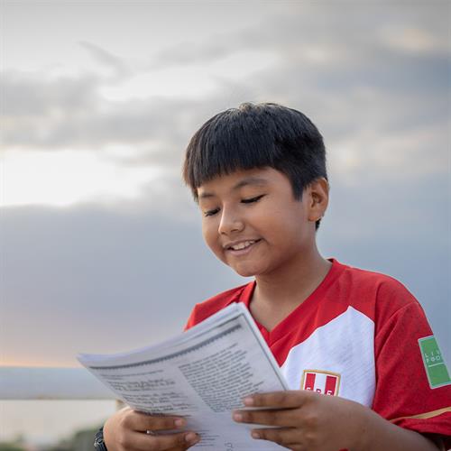 child smiles while reading letter