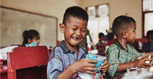 boy smiles while holding gift