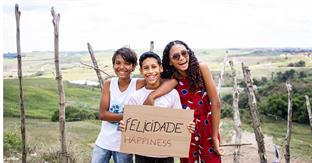 children smile while holding sign