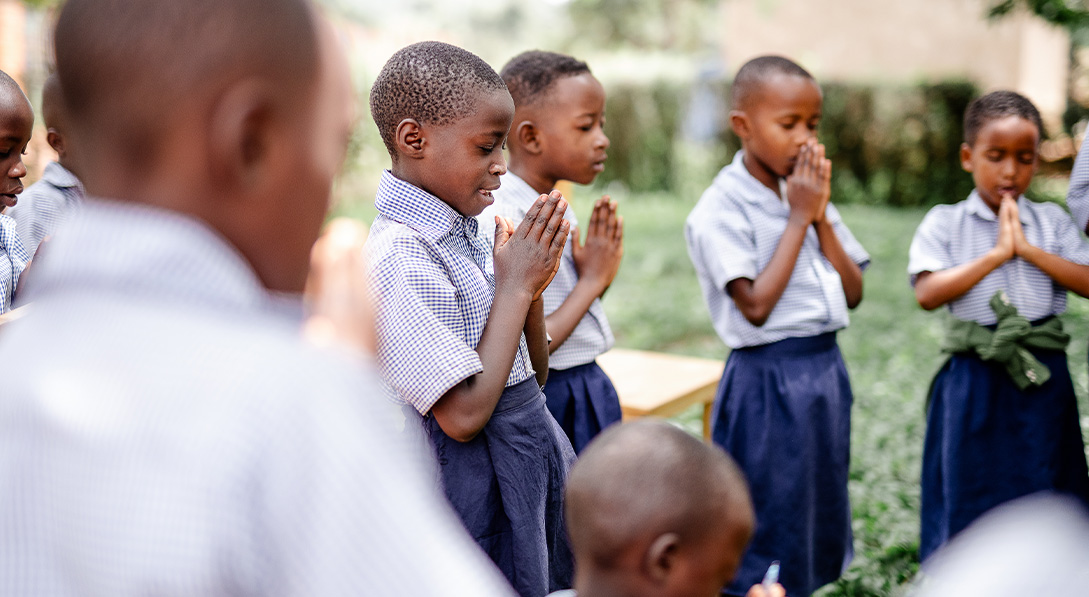 Rwandan children pray at their child development center.