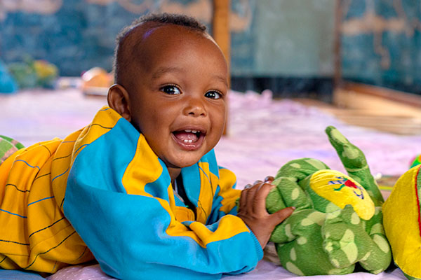 A smiling child with a toy