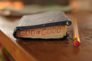Close up of a bible with the words "God is good" on it