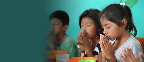 Children pray before a meal