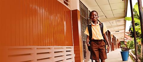A boy walking through a school smiling