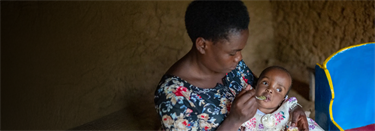 A mother feeding her baby with a spoon