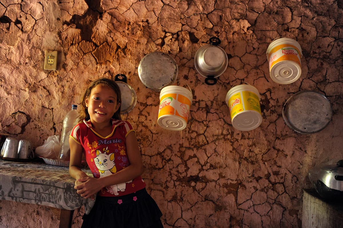 Girl in a kitchen with buckets hanging on the wall